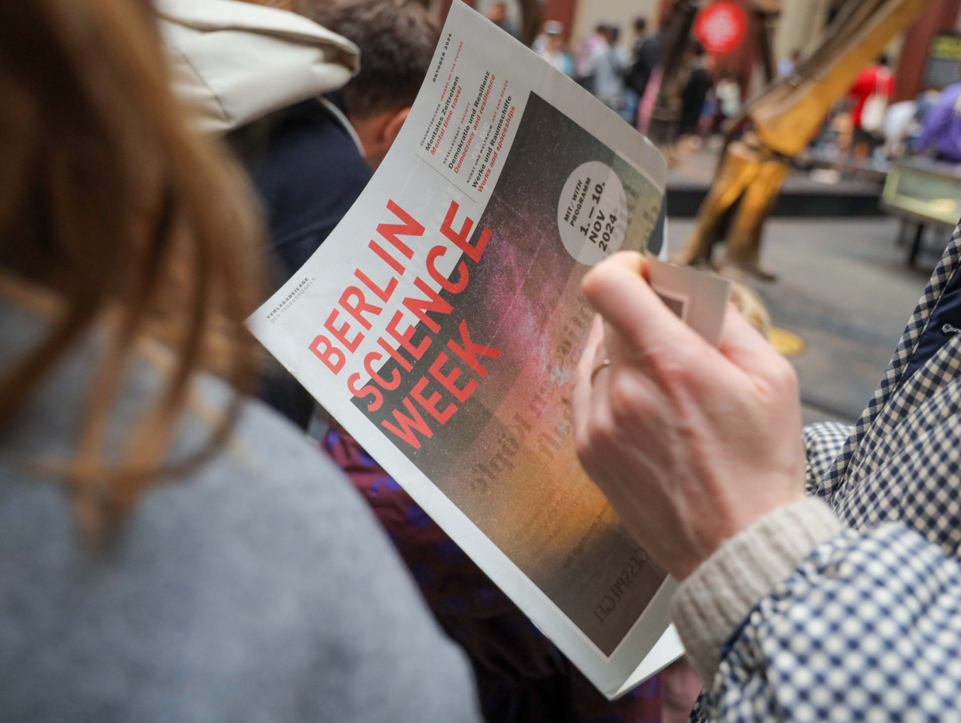 Person reads Berlin Science Week Magazine