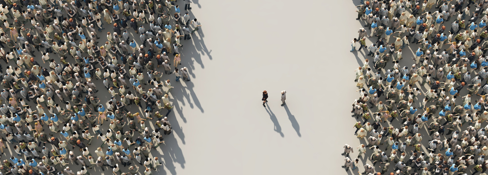 An image from above of two groups of people separated by n empty street, with two people in the middle