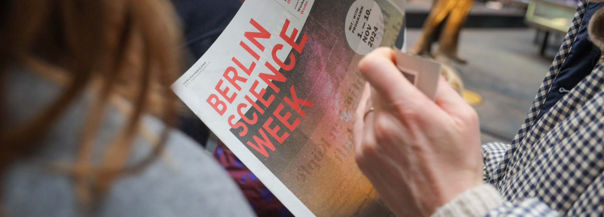 Person reads Berlin Science Week Magazine