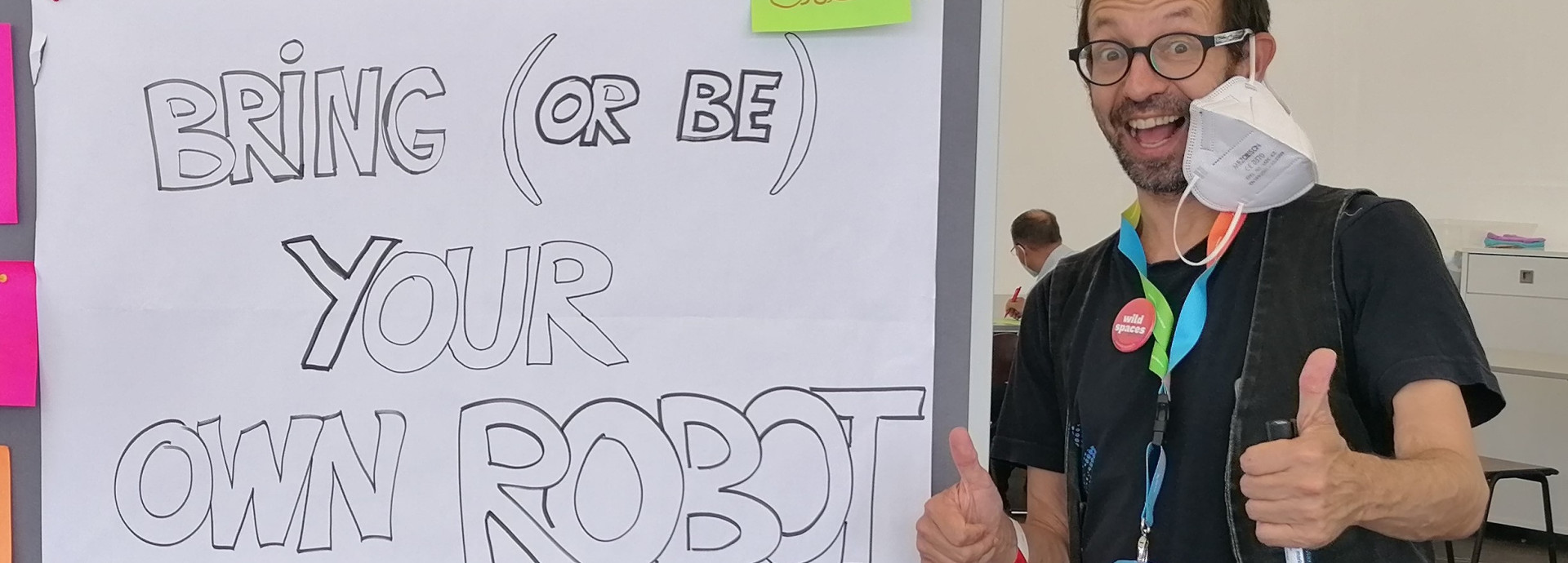 TeeKay neben einem Schild: Bring your own robot ! Bring Deinen eigenen Roboter mit