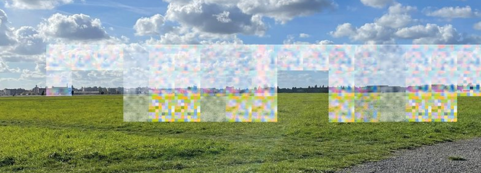 Eine weitläufige grüne Wiese unter einem blauen Himmel mit weißen Wolken. In der Mitte sind bunte, verpixelte Kästchen, die den Hintergrund verzerren.