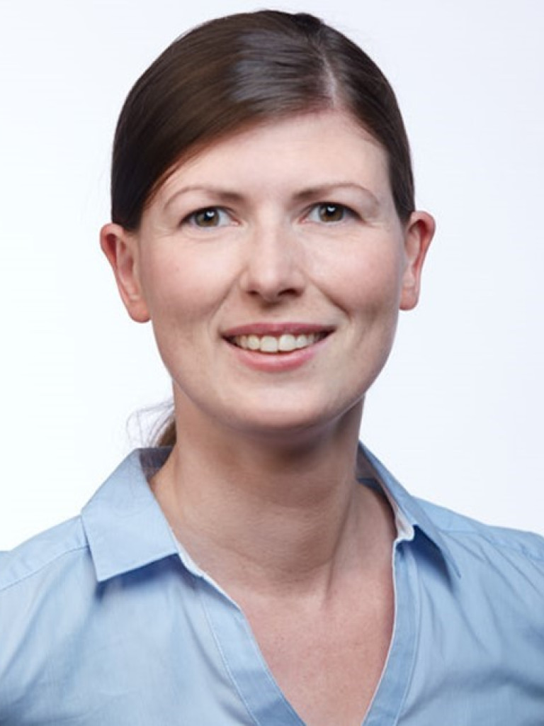 Headshot of Deetje Iggena. She is smiling, wearing a blue shirt and hair in a pony tail.
