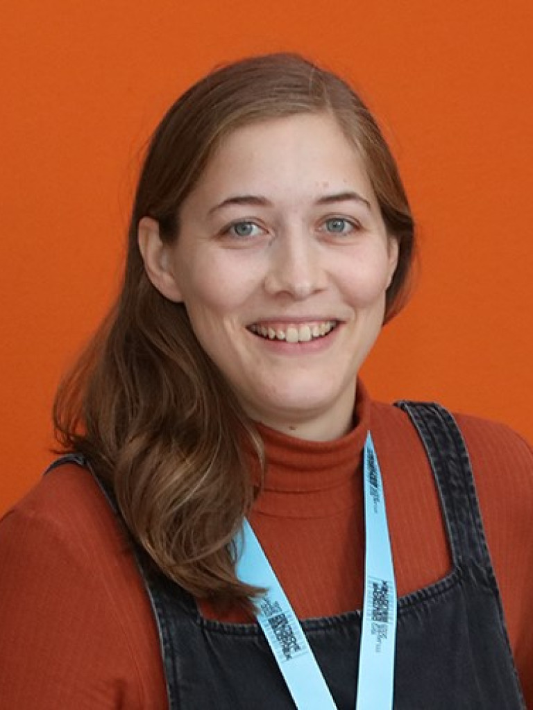 Junge Frau vor orangefarbigen Hintergrund 