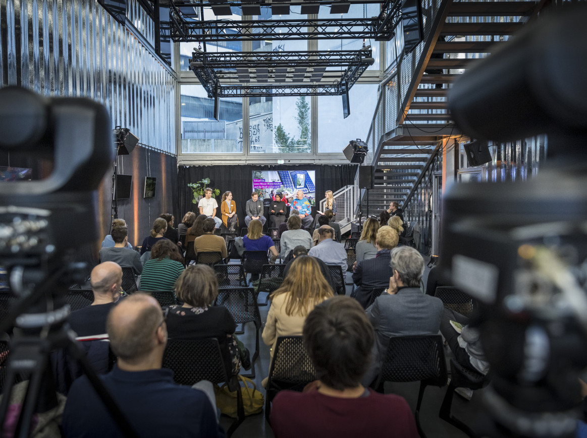 A shot from behind of a room full of people