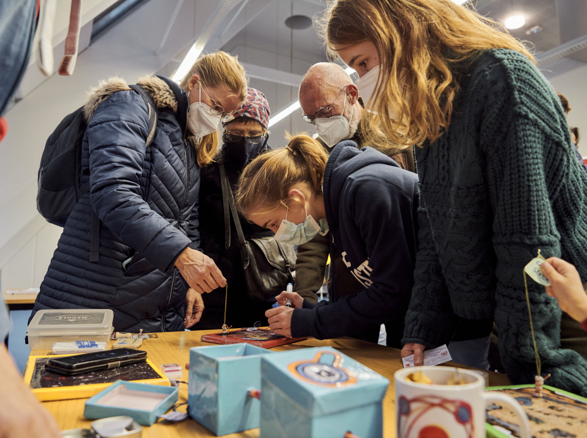 A shot from below of several people playing with objects on a table