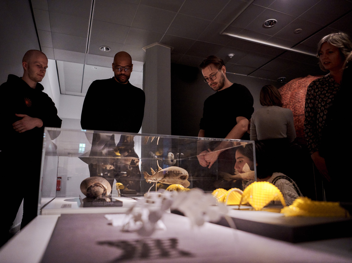 A shot of people looking at artwork on a table
