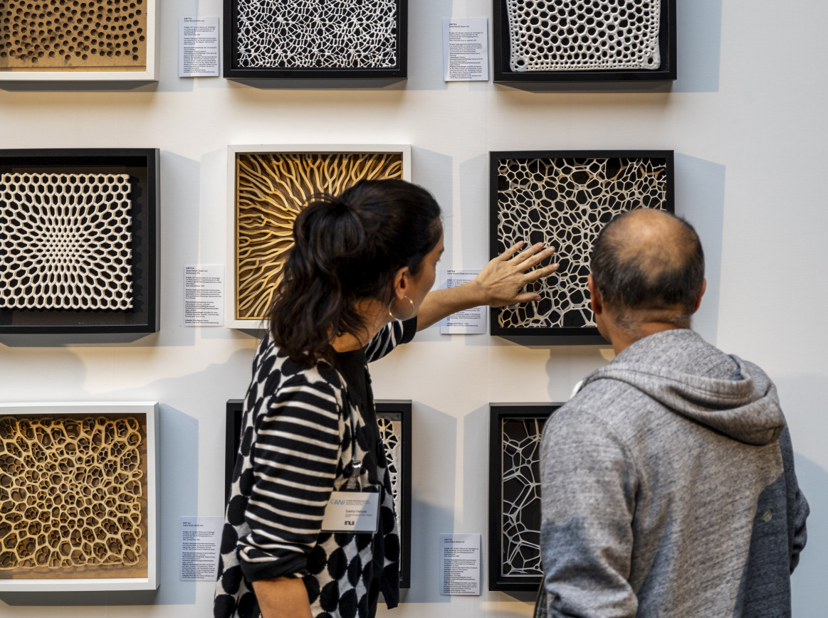 Two people looking at exhibits on a wall