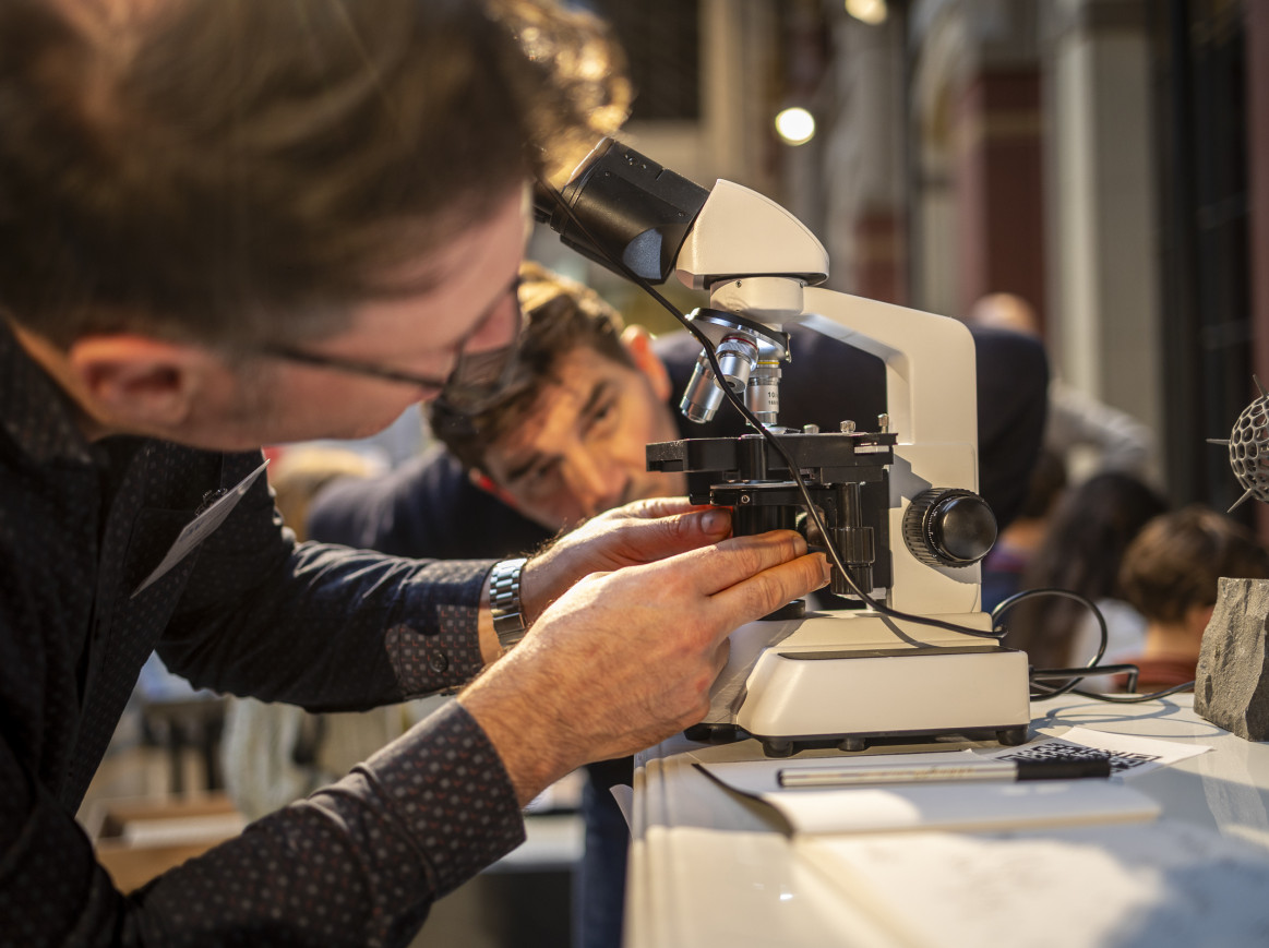 Two man looking at a microscope