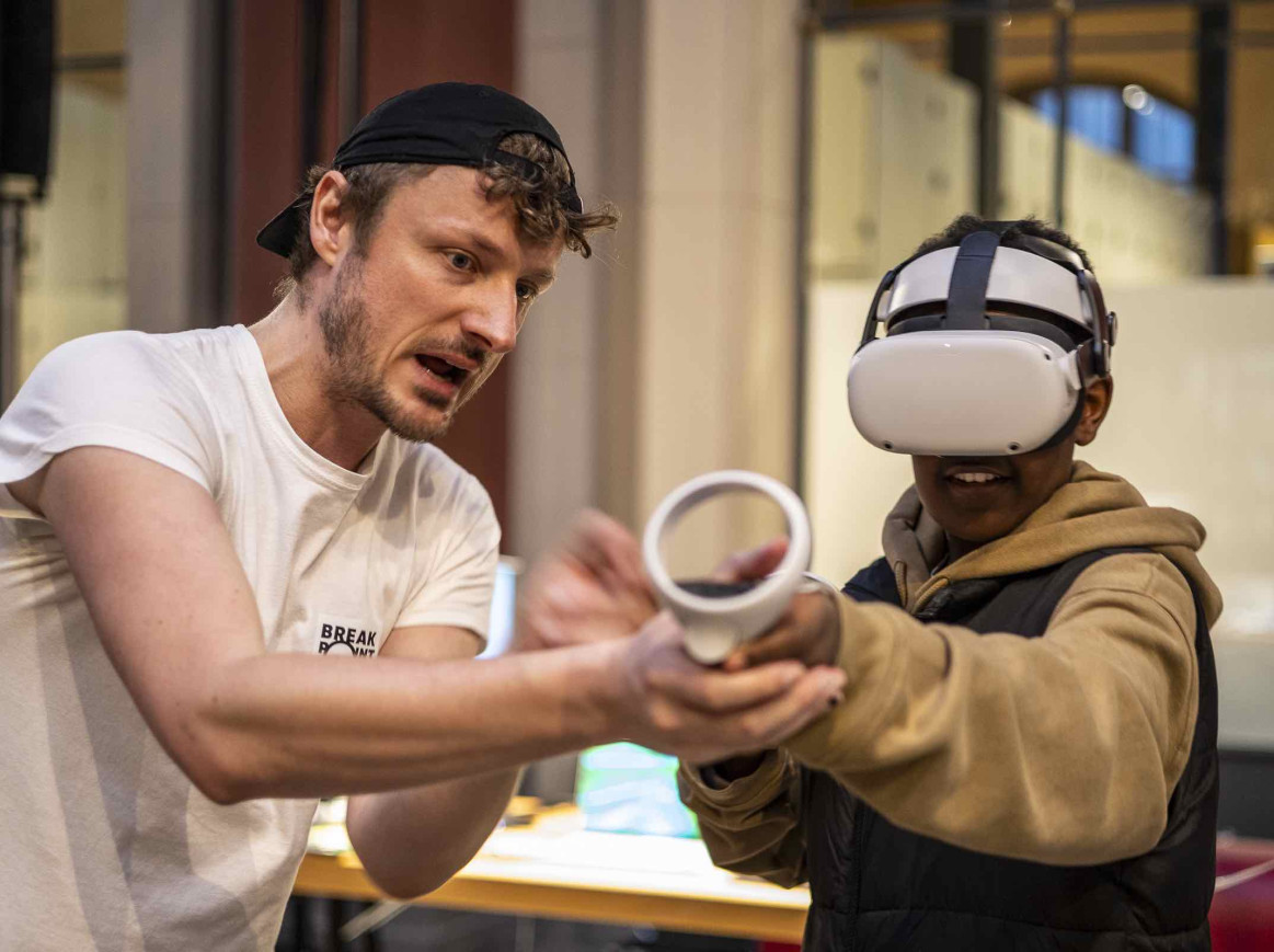 man showing a boy how to use VR