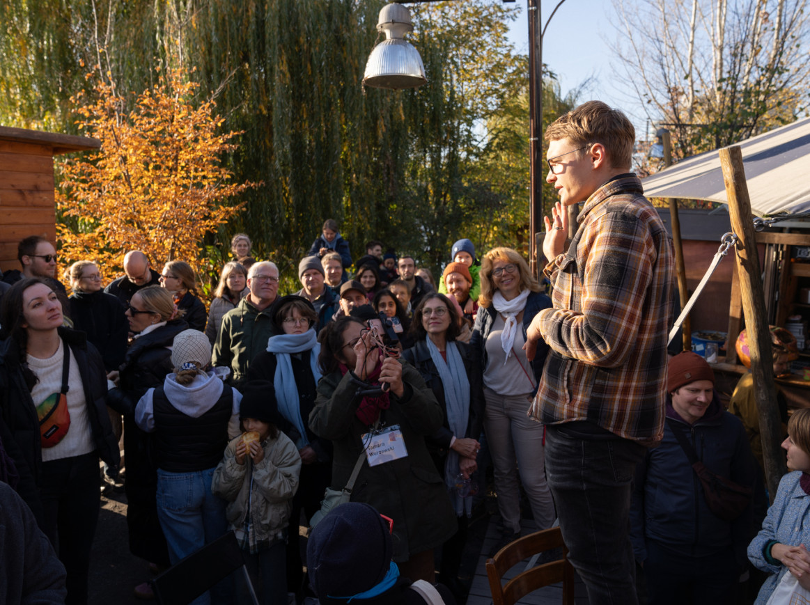 Plantfluencer Robinga speaks to a group of people in the outdoor area of the Holzmarkt