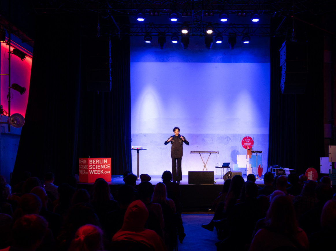 Nahum performing 'Spells' in the Säälchen, with the stage illuminated in blue