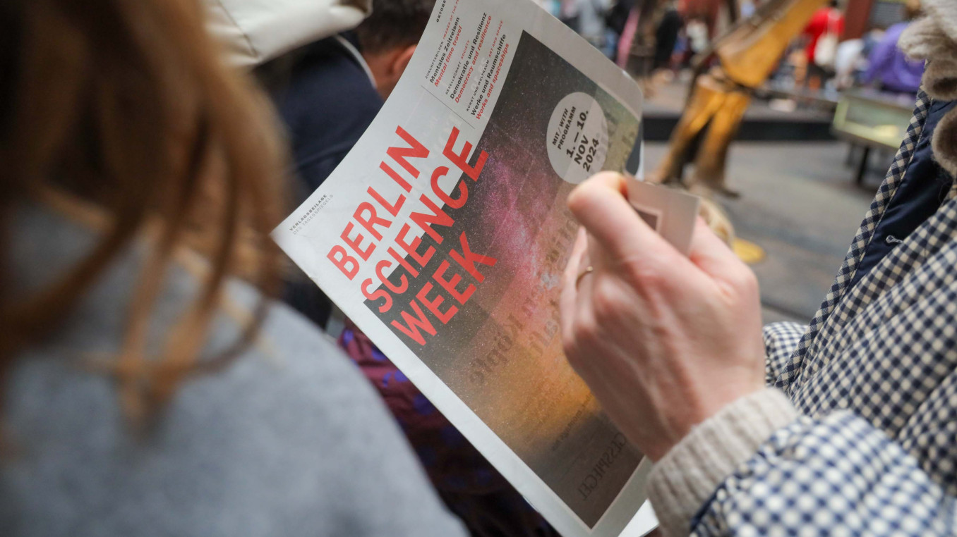 Person reads Berlin Science Week Magazine