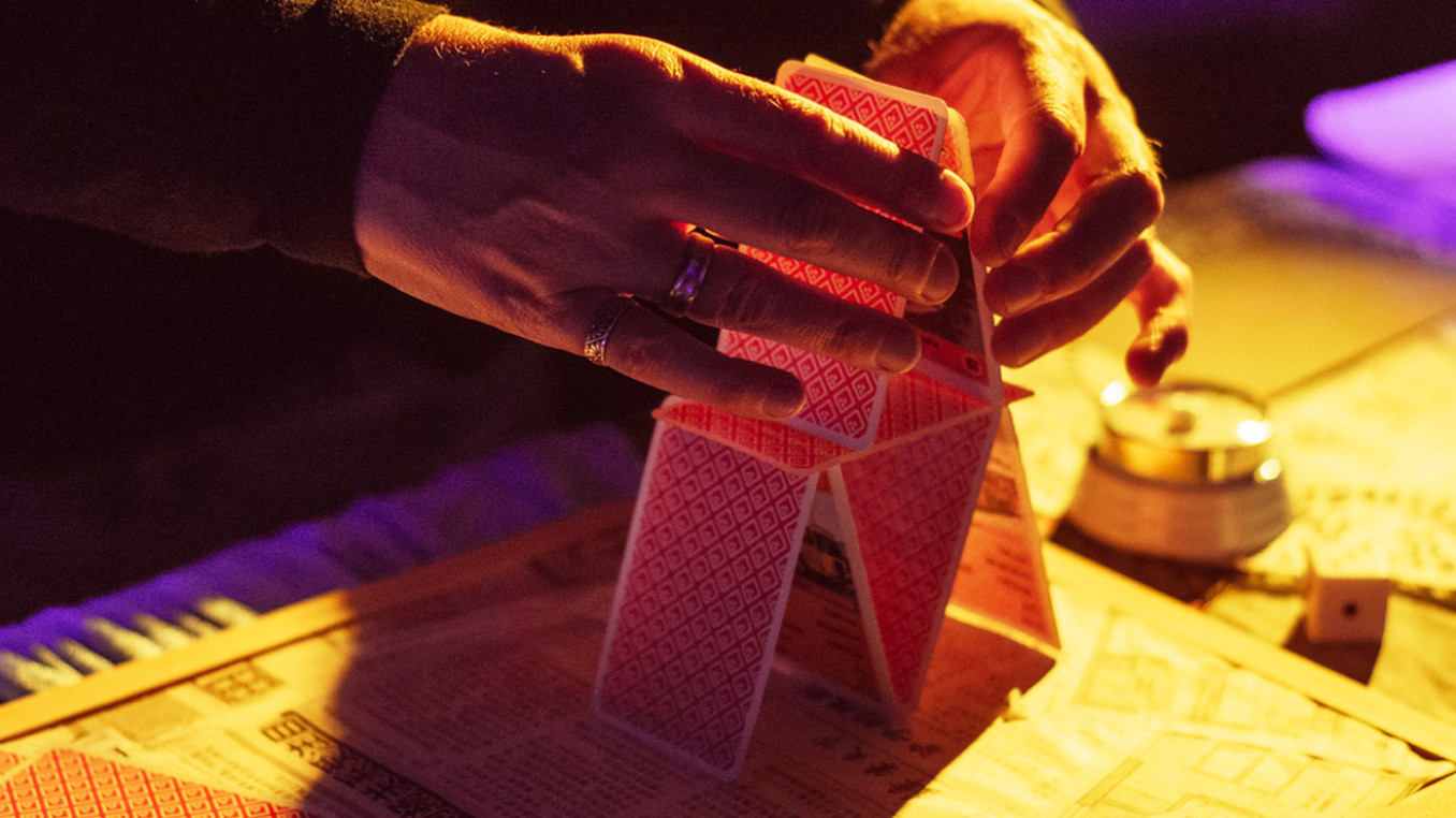 hands building a house of cards